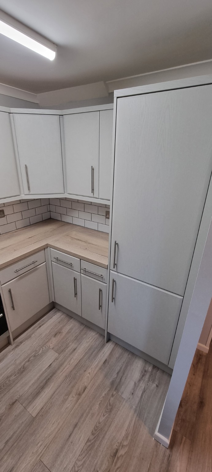 Light grey framed tall-unit doors beside the finished corner worktop