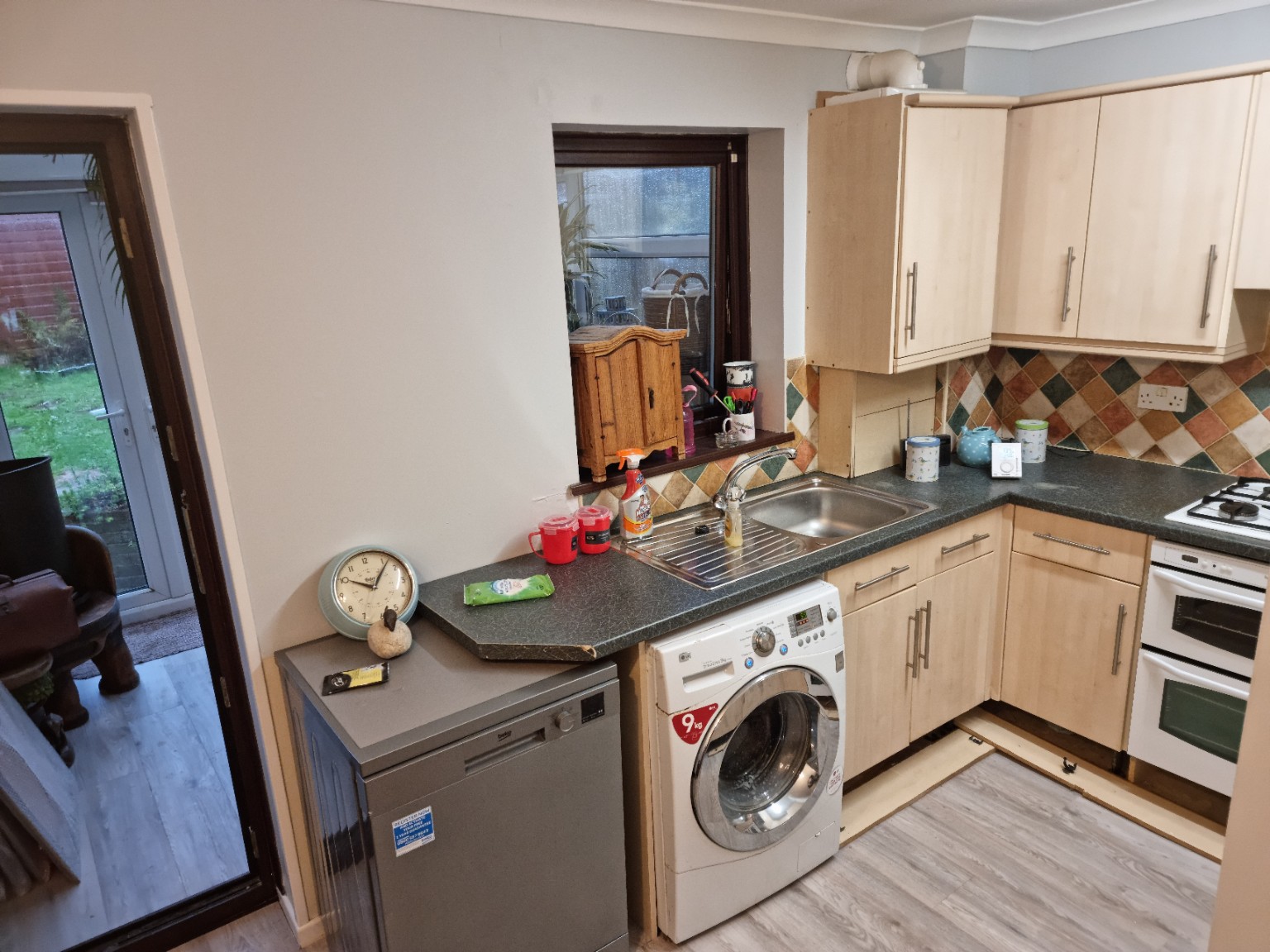 Original sink run with dark worktop and pale wood-effect doors